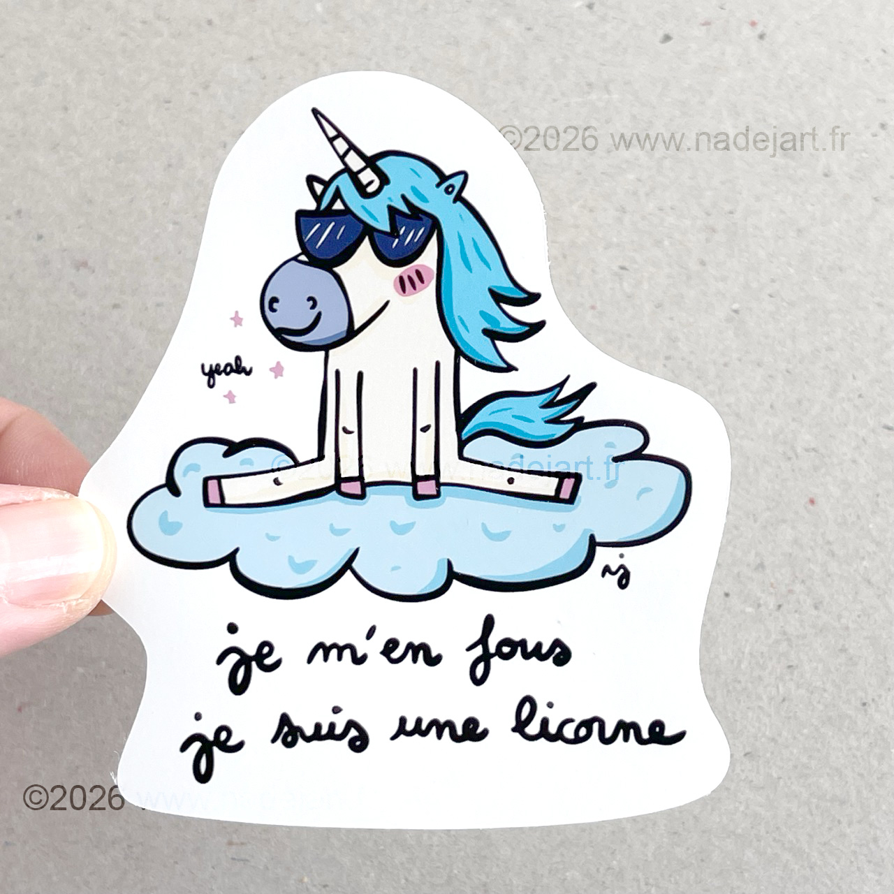 sticker en vynil blanc brillant avec une licorne avec une crinière bleue assise sur un nuage et une phrase d'humour ©2026 www.nadejart.fr